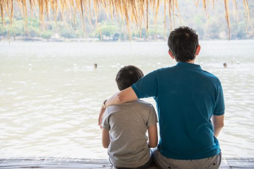 happy-dad-son-during-vacation-water-site-nature Happy dad and son during vacation at water site nature - happy family vacation concept